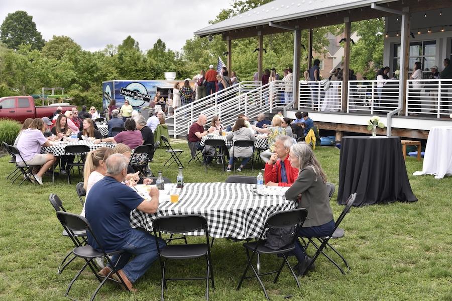 people seated at tables outside of Hodson Boathouse